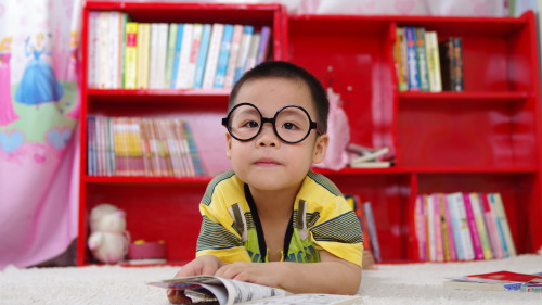 Kind mit Brille und Zeitung