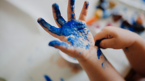 Kinderhand mit blauer Farbe